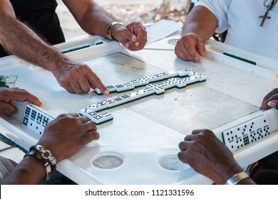 Close up view of individuals playing the domino game in the historic Domino Park in popular Little Havana.