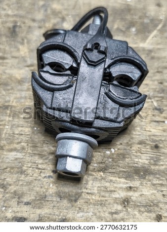 Close view of an insulation piercing connector on top of a wooden working table