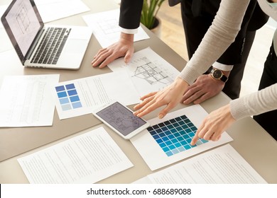 Close up view of Interior designers teamwork with pantone swatch and house building plans on office desk, architects working with blue color palette to choose best paint for home refurbishment - Powered by Shutterstock