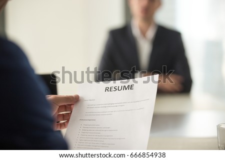 Close up view of job interview in office, focus on resume writing tips, employer reviewing good cv of prepared skilled applicant, recruiter considering application, hr manager making hiring decision 