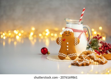 close up view jug of milk with gingerbread cookie with Christmas lights on background. Christmas. Festive homemade decorated sweets - Powered by Shutterstock