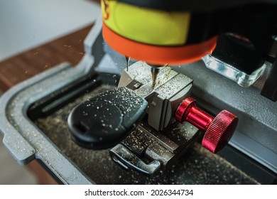 Close view of key copying machine with key. Duplicate machine make new key. Locksmith theme. Blank keys for cutting. Black modern car door opener.