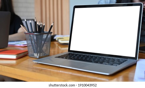 Close Up View Of Laptop Computer With Empty Screen And Stationery On Wooden Office Desk.