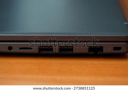 A close view of a laptop's side shows various ports including USB, HDMI, and card reader. This setup is useful for connecting different devices.