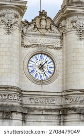 Close up view of the large clock and Paris Orleans sign on the facade of the historic Gare de Tours railway station building in Tours France creating a classic travel architecture detail view