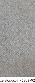 A close up view of a light gray textured surface with a subtle crosshatched pattern throughout.