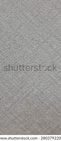 A close up view of a light gray textured surface with a subtle crosshatched pattern throughout.