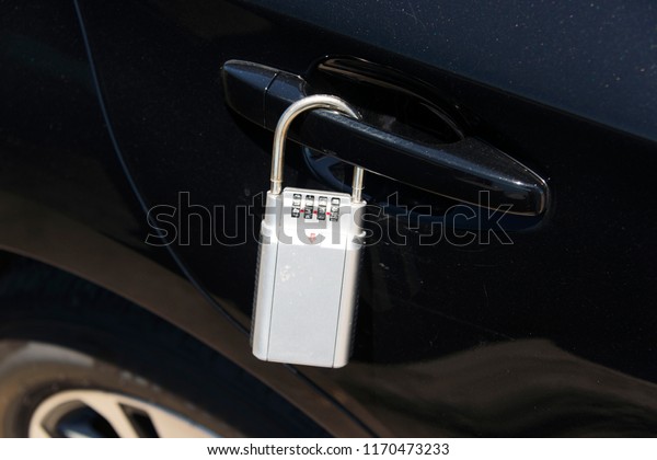 A close up\
view of a lock box on the car\'s\
door