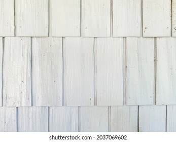 close up view looking at white shingles siding on boathouse barn or house