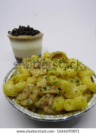 Close up view of macaroni schotel mac n cheese with elbow macaroni pasta cheesy cream, sausage beef meat cornet with a cup glass dessert of cold sweet  pudding chocolate milky white vanilla brown  Foto stock © 