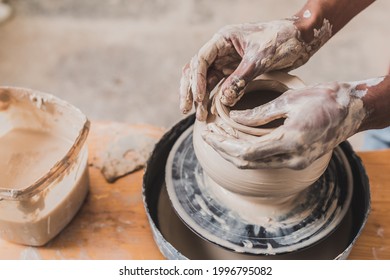 Close Up View Of Male African American Hands Sculpting Clay Pot On Wheel In Pottery
