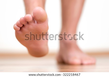 Close view of male feet making a step over home-like background.