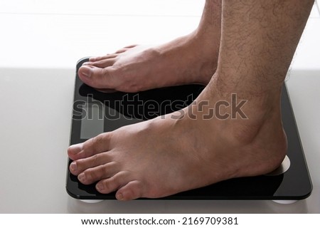 Close up view of male feet on the scales. health care concepts about weight loss, body weight gain