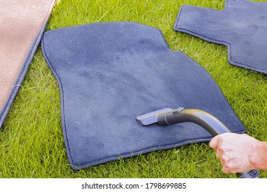 Close Up View Of Male Hand With Hoover Vacuuming Summer Car Mats. 