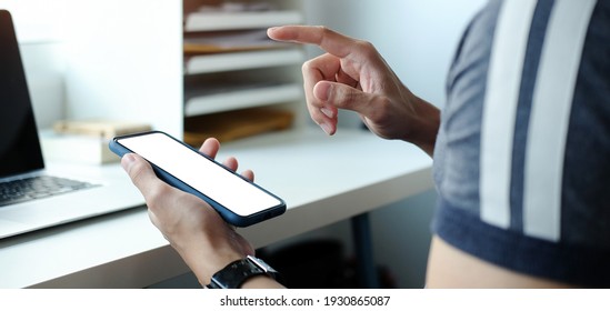 Close up view of male hands using smart phone with modern office blurred background. Blank screen monitor for graphic display montage. - Shutterstock ID 1930865087
