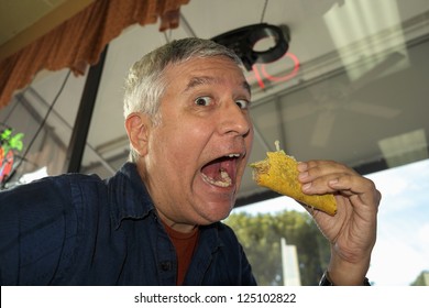 Close Up View Of A Man Eating A Taco In A Restaurant.