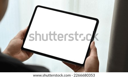 Close up view of man hands holding mock up digital tablet. White empty screen for text information or content