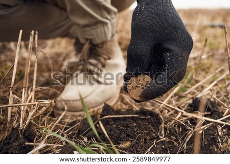 Close up view of man that found old coin on the field.
