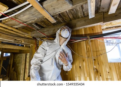 A Close Up View Of A Man At Work In Full PPE (personal Protective Equipment), Used To Protect From Airborne Mold Spores (aspergillus) During A Home Assessment.