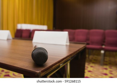 Close up view of microphone on table at press conference hall or seminar room background