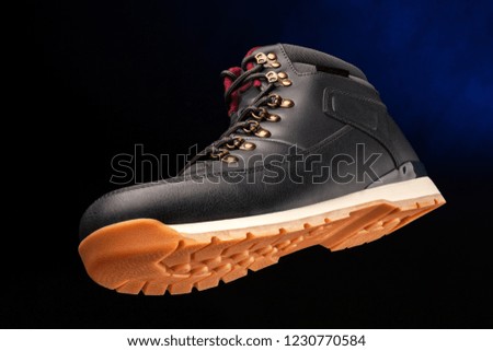 Close up view of a modern black boot on dark blue background. Stock photo © 