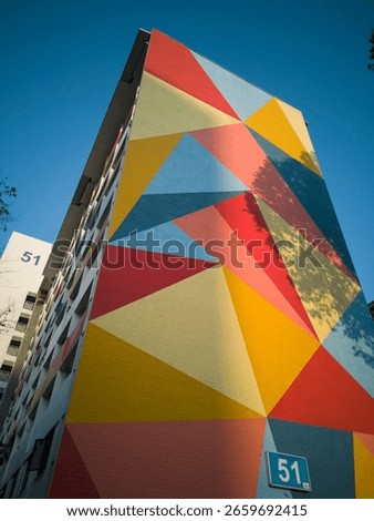 Close up view of modern colourful triangular design on a tall residential housing block in an old Singapore HDB public housing estate