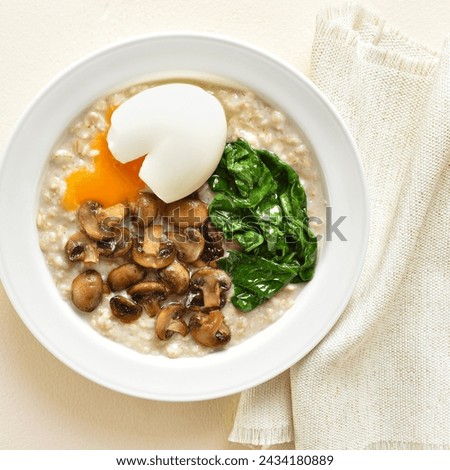 Close up view of mushroom and spinach oatmeal on plate over light background. Top view, flat lay