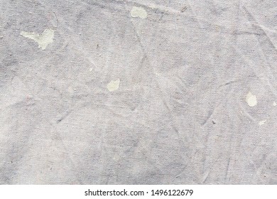 Close View Of A Muslin Drop Cloth With Off White Paint Spills And Splotches.