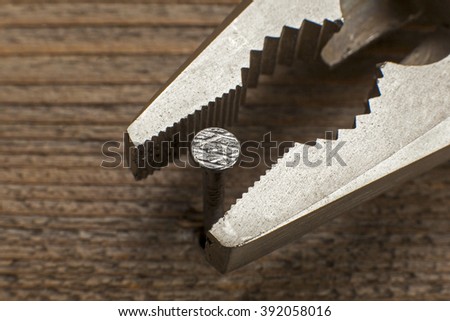 close up view of a nail and a pliers 