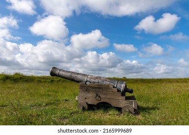 Close up view of old canon as illustration on the bastion or bulwark structure projecting outward at De Schans in Ouddorp, the Netherlands, a 17th century fortress now covered by grass - Shutterstock ID 2165999689