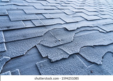 Close Up View On Asphalt Roofing Shingles Roof Damage Covered With Frost.