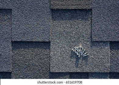 Close Up View On Asphalt Roofing Shingles And Nails Background. 