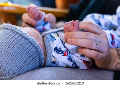 A Close Up View On The Hands Of A Woman Wearing Wedding Ring. Mother Enjoying Postpartum Period In Days After Birth. Strong Bond Between Mom And Son