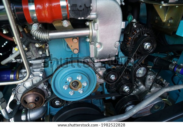 Close up view on new bus electric engine
compartment, motor belts, pulleys, gears, alternator and other
engine equipment. Assembled bus, truck diesel engine. Abstract
automotive industrial
background