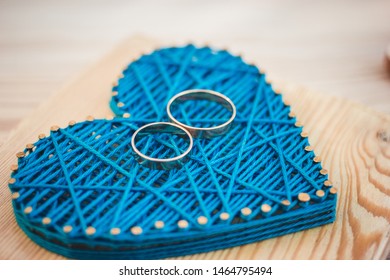 Close Up View On String Art Heart With Two Wedding Rings On It. Wedding Decor Concept Idea