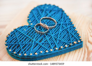 Close Up View On String Art Heart With Two Wedding Rings On It. Wedding Decor Concept Idea