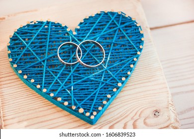 Close Up View On String Art Heart With Two Wedding Rings On It. Wedding Decor Concept Idea