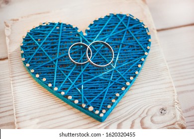 Close Up View On String Art Heart With Two Wedding Rings On It. Wedding Decor Concept Idea