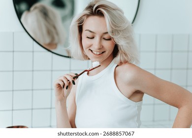 Close up view on toothbrush with toothpaste in smiling blonde woman hand. Whitening, morning routine
