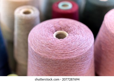 Close Up View On The Top Of A Large Cone Or Reel Of Natural Pink Cashmere Wool In A Knitwear Factory With Copyspace