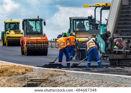 Close view on the workers and the asphalting machines