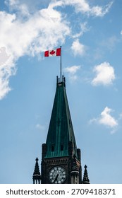 Close view of the Peace Tower clock and the Canadian flag atop Parliament Hill, a landmark symbol of the Canadian government