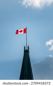 Close view of the Peace Tower clock and the Canadian flag atop Parliament Hill, a landmark symbol of the Canadian government