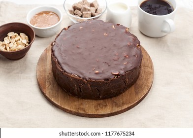 Close Up View Of Peanut Butter Chocolate Caramel Cheesecake Pie And Cup Of Coffee On Dining Table With Linen Tablecloth. A Sweet Coffee Break Concept
