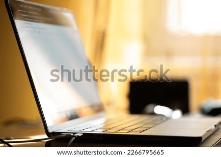 close up view of a personal computer in perspective on a desk, lit up by the sunlight in backlight. Technology, smart-working and modern communications concepts