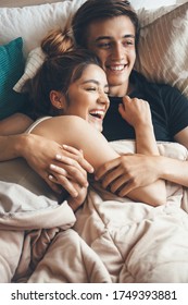 Close View Photo Of A Happy Couple Lying In Bed And Embracing Early Morning