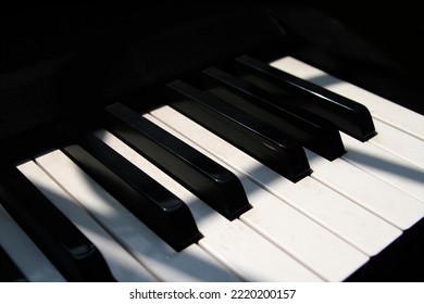 Close Up View Of Piano Keyboard Near Window With Shadow Overlay Effect. Piano Key Sunny Effect. Electric Piano Keyboards In Four-line Octave. White Keys And Black Keys. Piano Sunlight Wallpaper Art