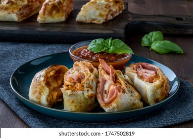 A Close Up View Of Pieces Of Stromboli On A Plate With Pizza Dipping Sauce, Ready For Eating.