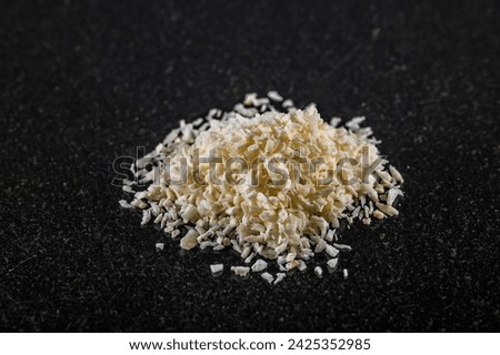 A close up view of a pile of desiccated coconut on a dark marble platter