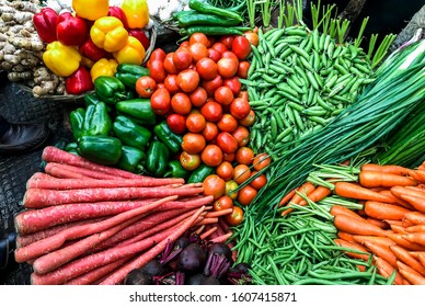 close up view pile of winter vegtables tomato green pees red carrot capssicum orrange carrot bell paper onion leaves beetroot ginger in the market